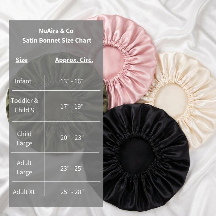 A satin bonnet size chart overlay on a white satin fabric background, with four satin bonnets in black, cream, and pink arranged around the chart. The chart lists sizes from Infant to Adult XL with approximate circumferences.