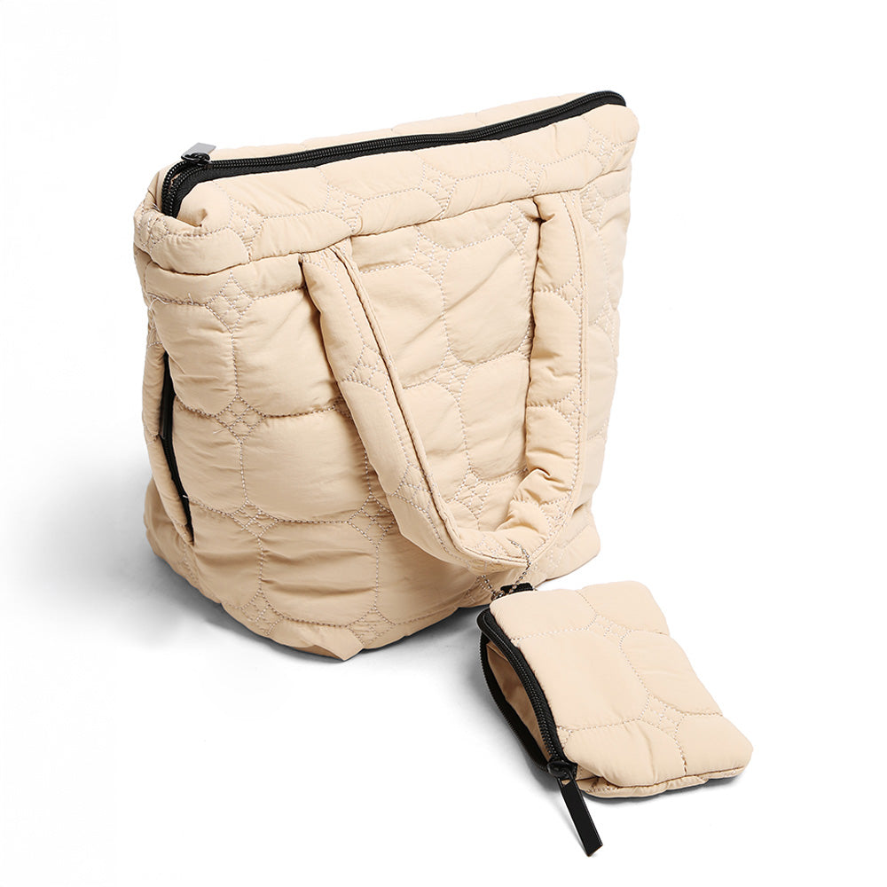 A quilted beige tote bag with black zipper trim, shown with a matching small zip pouch on a light gray background.