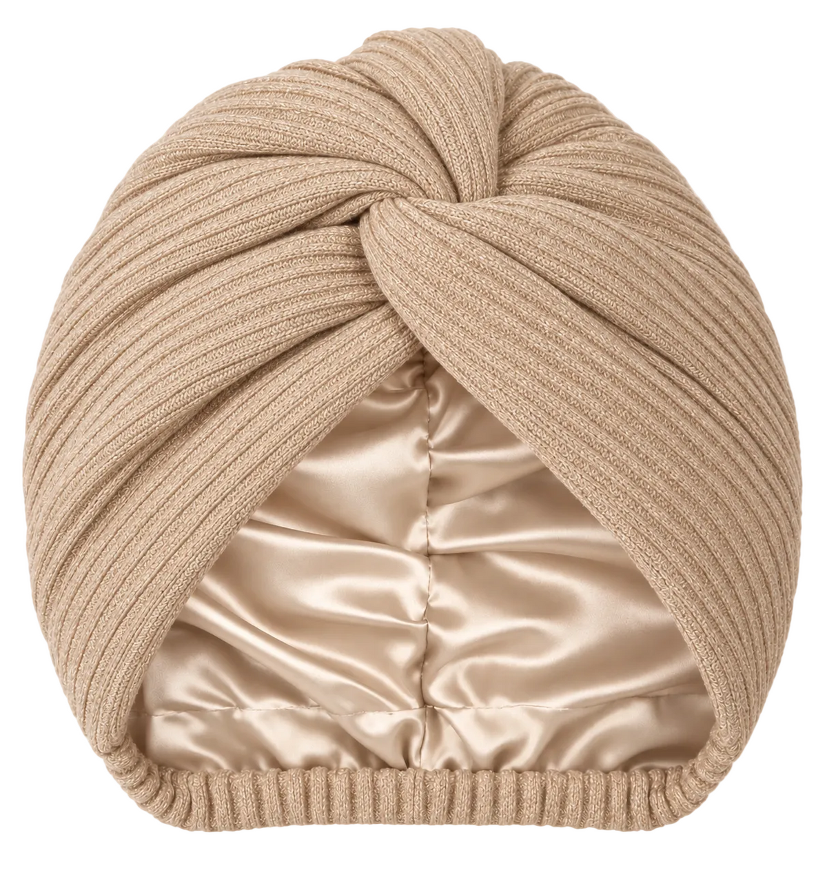 A beige ribbed knit turban hat featuring a central front twist detail. The interior is lined with a smooth, champagne-colored satin fabric. A small black rectangular tag with the white text "ALAIRA" is attached to the side edge.