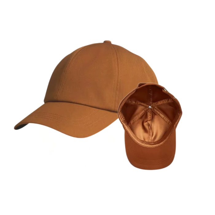 A warm brown baseball cap shown from the side and back, with a small black NUAIRA brand label on the left, set against a plain white background.