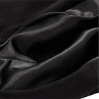 A close-up of draped black satin or silk fabric with soft folds and a subtle sheen.