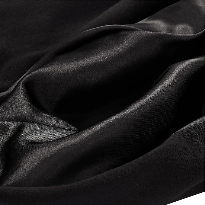 A close-up of draped black satin or silk fabric with soft folds and a subtle sheen.