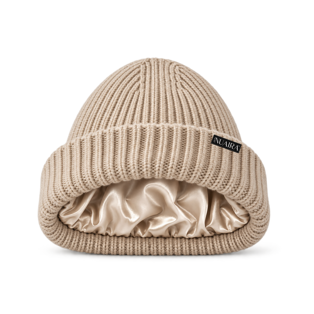 Oatmeal Cream black ribbed knit beanie hat with a shiny oatmeal cream satin inner lining, shown on a white background with a oatmeal cream NUAIRA brand tag in the lower left corner.