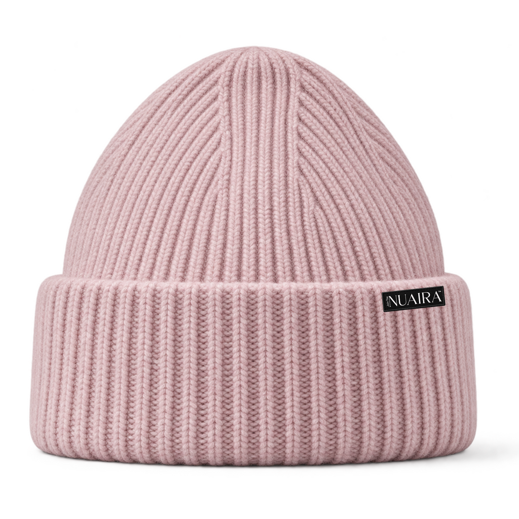 Pink ribbed knit beanie hat with a shiny black pink inner lining, shown on a white background with a pink NUAIRA brand tag in the lower left corner.