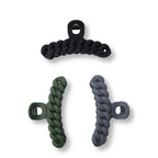 Set of three matte twisted hair claw clips in black, green, and slate gray on white background