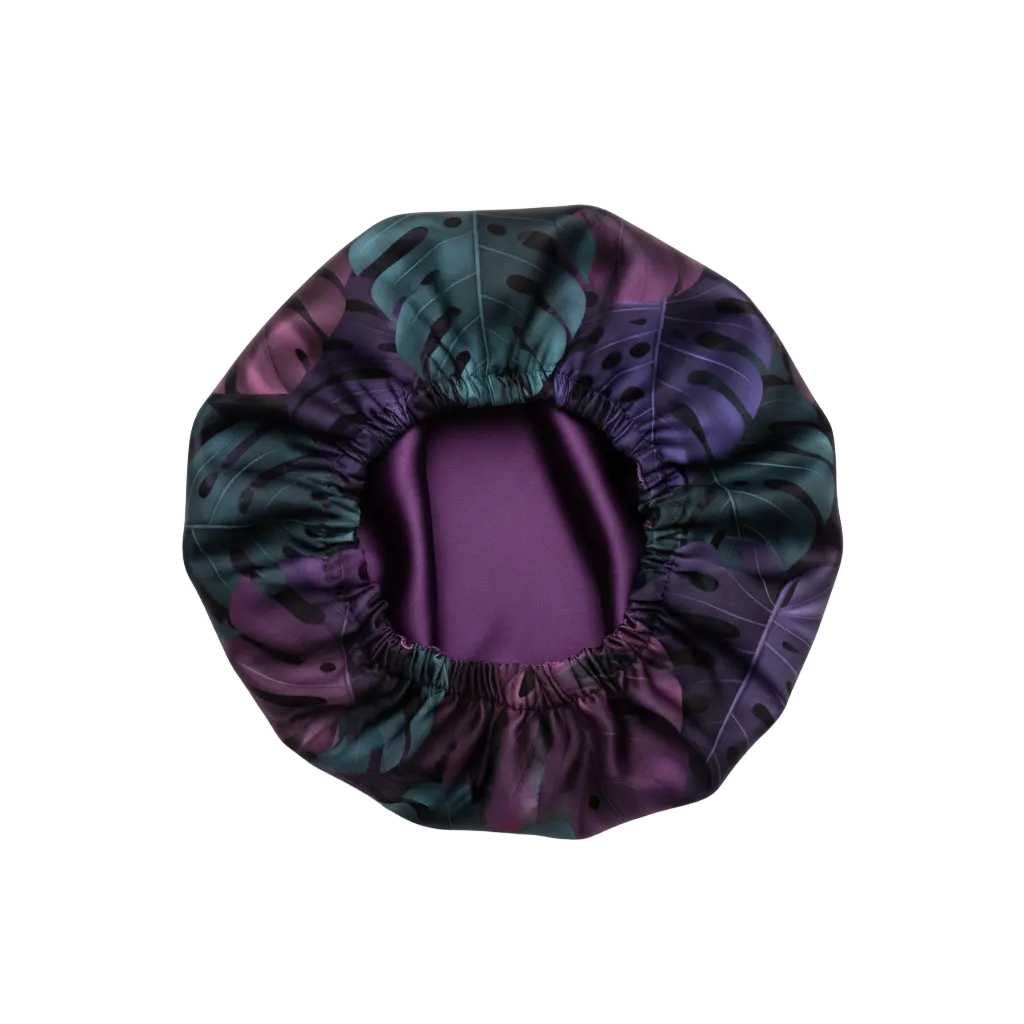 NuAira Starlie Foliage satin fabric swatch – dark teal and purple monstera leaf print for hair bonnet